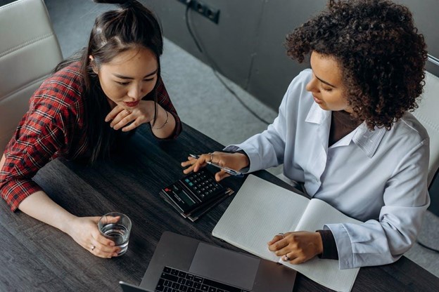 Two women discussing about Business Income Insurance.